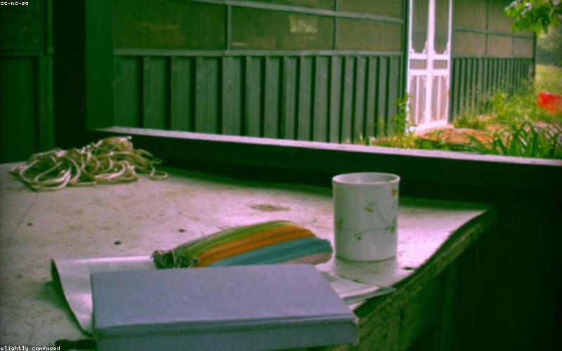 Open journal and cup of tea on wooden table